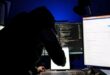 A hacker in front of computer monitors