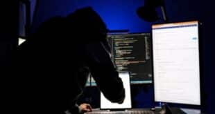 A hacker in front of computer monitors