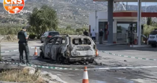 Burnt-out car near service station in Granada province